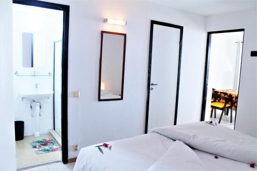 a bedroom with two beds and a sink and mirrors at Bungalow Beach Hotel in Serekunda