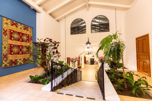 a hallway of a house with a staircase with plants at Plaza Chapala Hotel in Chapala