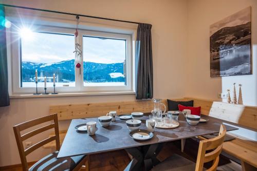 a dining room with a table and a large window at Chalet Tirol in Westendorf