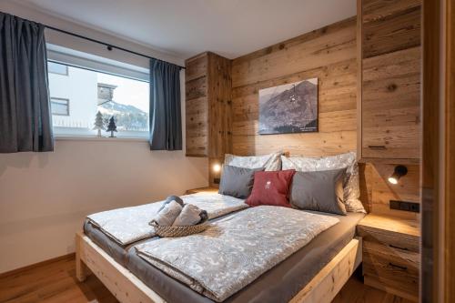 a bedroom with a bed with a wooden wall at Chalet Tirol in Westendorf