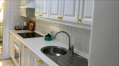 a kitchen with a sink and white cabinets at MI CAPRICHO A17 Beachfront Apartment in La Cala de Mijas