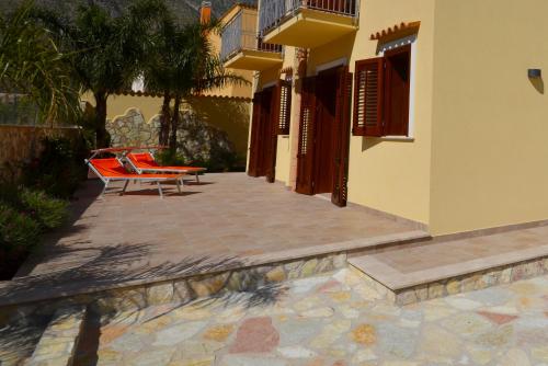 a patio with two chairs and a building at Le Falesie di Castelluzzo in Castelluzzo