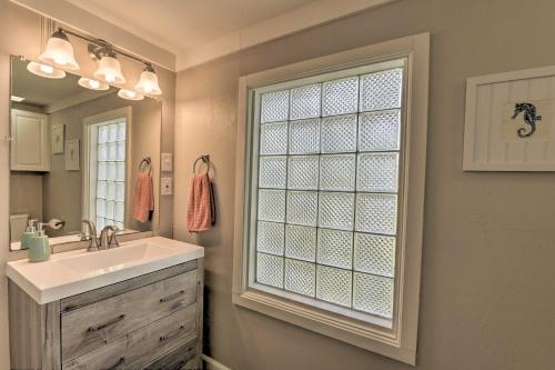Un baño con lavabo y una gran ventana. en Steps to Sand Galveston Beach Bungalow!, en Galveston
