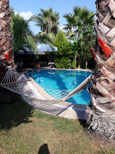 a hammock in front of a swimming pool at Jasmin Apart Otel in Göcek