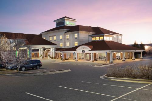 a hotel with a car parked in a parking lot at Holiday Inn Grand Rapids-Airport by IHG in Grand Rapids