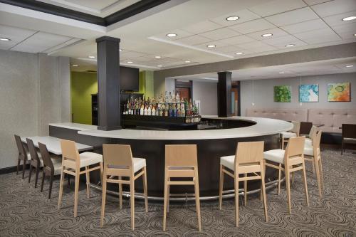 a bar in a hotel room with chairs and a counter at Holiday Inn Grand Rapids-Airport by IHG in Grand Rapids