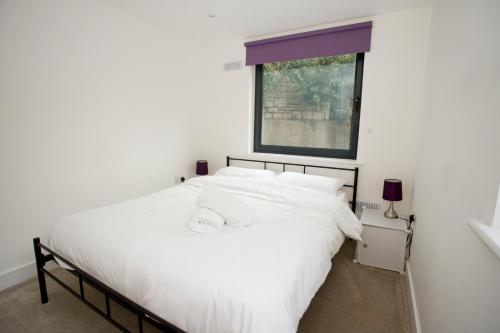 - un lit blanc dans une chambre avec fenêtre dans l'établissement 8 Compass Point, à Bournemouth