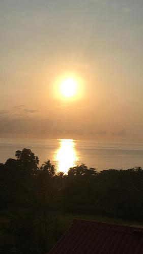 a sunset over the ocean with the sun in the sky at Domus Guesthouse in Santana