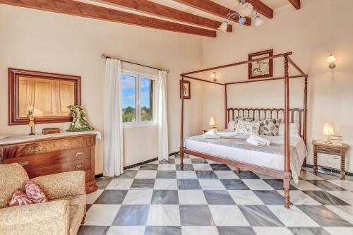 a bedroom with a canopy bed and a checkered floor at Can Claret in Caʼs Concos