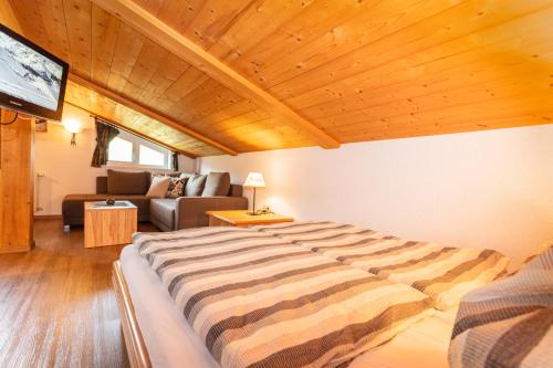 ein Schlafzimmer mit einem großen Bett und einem Sofa in der Unterkunft Appartement Bergfried in Kaprun