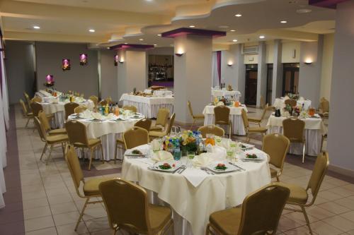 a banquet hall with white tables and chairs at Hotel Przedwiośnie in Masłów