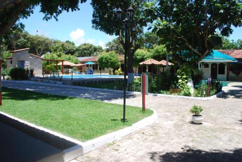 a courtyard with a swimming pool and a resort at Hotel Rusticos in Conceição da Barra