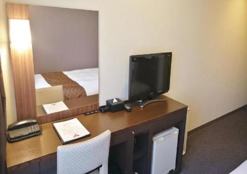 a room with a desk with a television and a bed at Hotel Ascent Plaza Hamamatsu / Vacation STAY 64697 in Hamamatsu