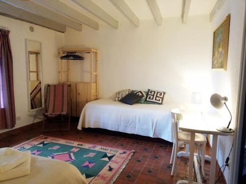 a bedroom with two beds and a table and a desk at Domaine des Goudis in Bouisse