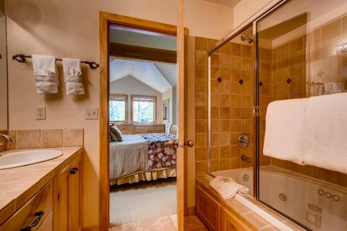 a bathroom with a sink and a shower and a bed at Foxglove Condos in Park City