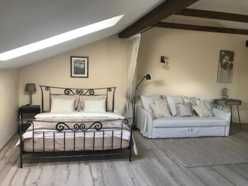 a bedroom with a bed and a couch at LizMari in Podčetrtek