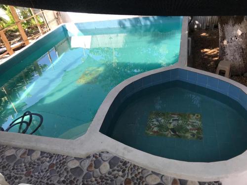 una gran piscina con azulejos azules en Cabaña La Fortaleza en Tolú