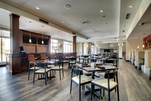 a restaurant with tables and chairs and a bar at Holiday Inn & Suites Peoria at Grand Prairie by IHG in Peoria