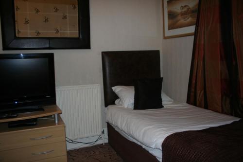 a hotel room with a bed and a flat screen tv at Royal Hotel in Girvan