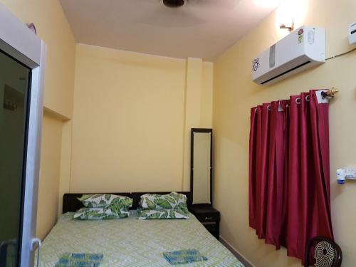 a bedroom with a bed and a red curtain at SM Guest House in Lucknow