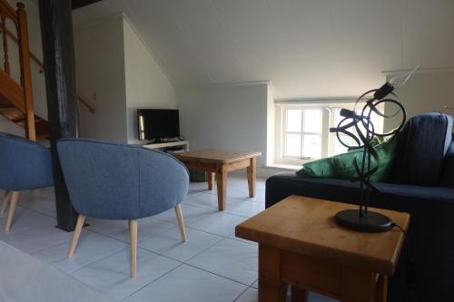 a living room with a couch and a table at Magnificent farmhouse in Central Holland 4A & 2C in Schoonrewoerd