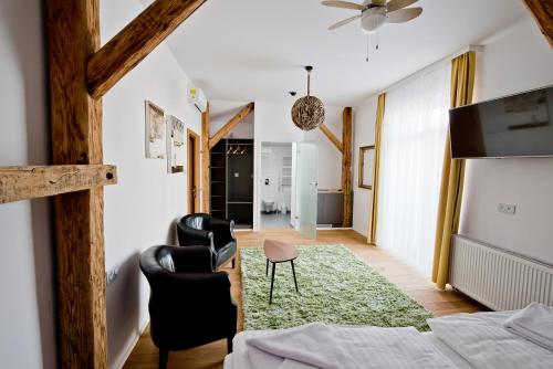 a bedroom with black chairs and a green rug at Salon Win Wine Bar & Apartments in Jasło