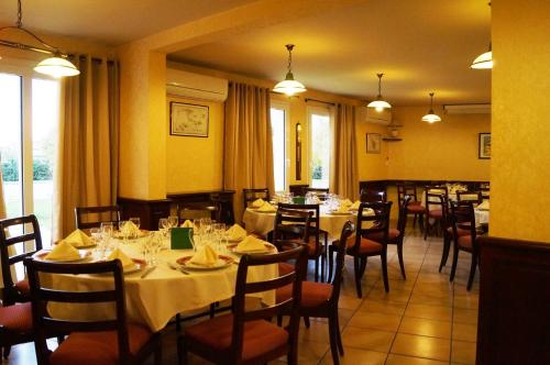 a dining room with tables and chairs in a restaurant at Hotel Restaurant La Martiniere in Montélier