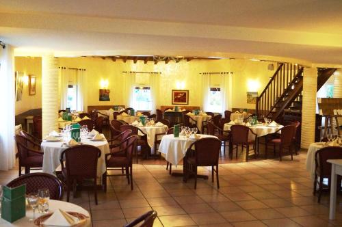 a restaurant with tables and chairs and a staircase at Hotel Restaurant La Martiniere in Montélier