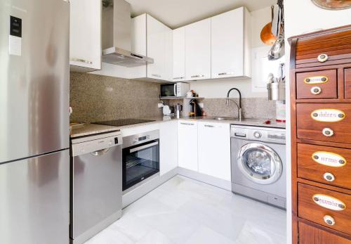 a kitchen with white cabinets and a dishwasher at ***** ATTIC WITH IMPRESSIVE VIEWS AND JACUZZI in Cádiz