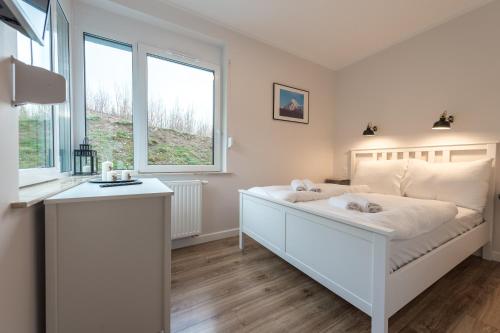 een witte slaapkamer met een groot bed en 2 ramen bij Apartament Tarasowy z SAUNĄ - 5D Apartamenty in Świeradów-Zdrój