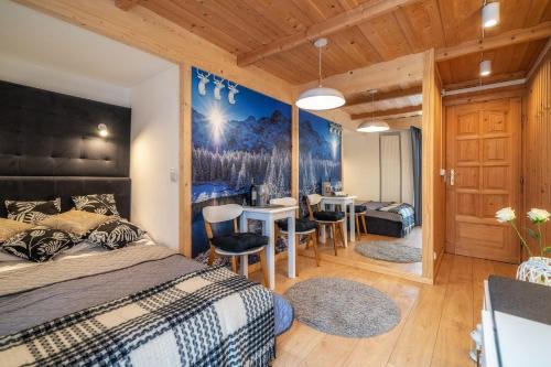 a bedroom with a bed and a dining room at Chałpa u Zbójnika in Zakopane