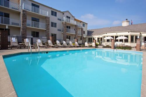 a large swimming pool at a hotel with chairs at Holiday Inn Express Hotel & Suites Pittsburgh Airport by IHG in Robinson Township
