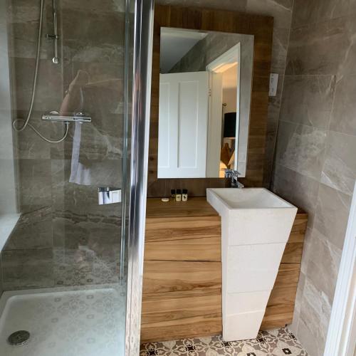 a bathroom with a shower and a sink and a mirror at Scarborough Hill Country Inn in North Walsham