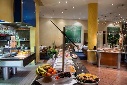 a buffet line with fruits and vegetables in a restaurant at Radisson Blu Fürst Leopold Hotel in Dessau