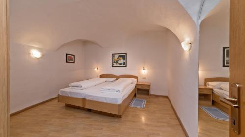 a bedroom with two beds and a hallway at Residence Chiavi D'Oro - Goldener Schlüssel in Bressanone