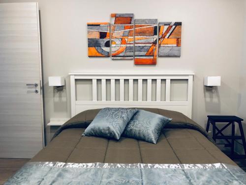 a bedroom with a bed with two paintings on the wall at Classic Home in Castelbuono