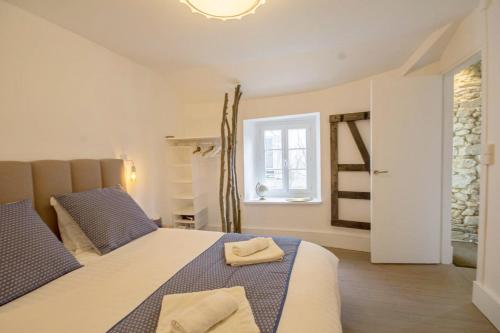 a bedroom with a bed with two towels on it at TY LAUMANN sur le PORT petite maison avec jardin - Parking gratuit in Vannes