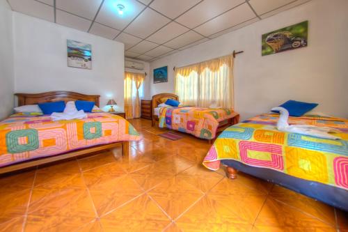 a bedroom with two beds in a room at Hostal Villamil in Puerto Villamil