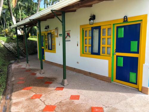 a building with blue and yellow doors on it at Finca Hotel Andaquies in Armenia