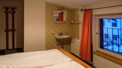 a bedroom with a bed and a sink and a window at Haus Luise in Westendorf