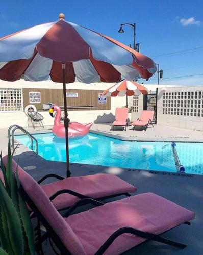 a swimming pool with a pink flamingo and an umbrella at RSVP Hotel in Bozeman