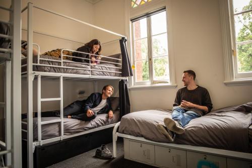 墨爾本的住宿－The Mansion Melbourne，一群人坐在一个房间里双层床上