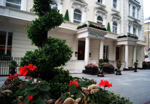 a garden with flowers and plants in front of a building at Aspen Hotel in London