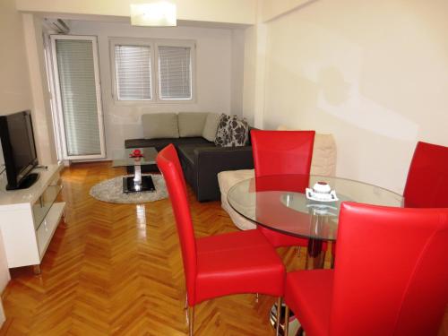 a living room with a table and red chairs at Apartments Jovan city center with free parking in Ohrid
