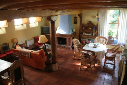 sala de estar con sofá, mesa y sillas en El Canto del Gallo, en Ranedo de Curueño