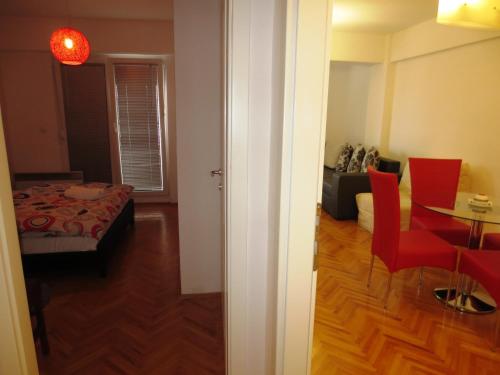 a room with a bed and a table and red chairs at Apartments Jovan city center with free parking in Ohrid