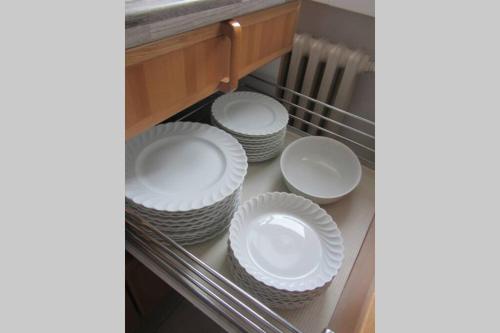 a group of white plates sitting on a shelf at Große Wohnung 20 km von Köln bis zu 17 Personen in Rösrath