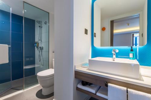 a bathroom with a sink and a toilet and a mirror at Holiday Inn Express Xi'an Ancient Town West, an IHG Hotel in Xi'an