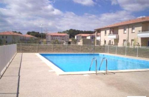 een groot zwembad voor een gebouw bij Appart Chrystal in Carcassonne