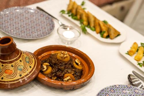 a bowl of food on a table with plates of food at Palais Houyam in Fès